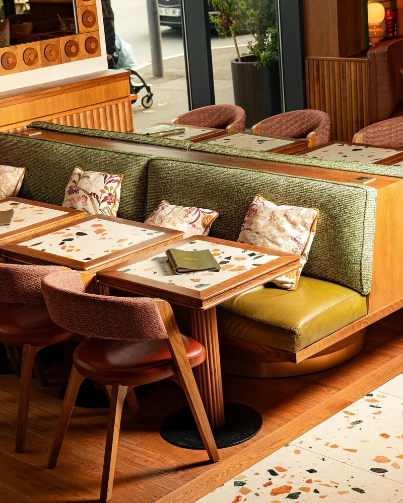Billy’s light-filled dining room with green banquettes and pink armchairs