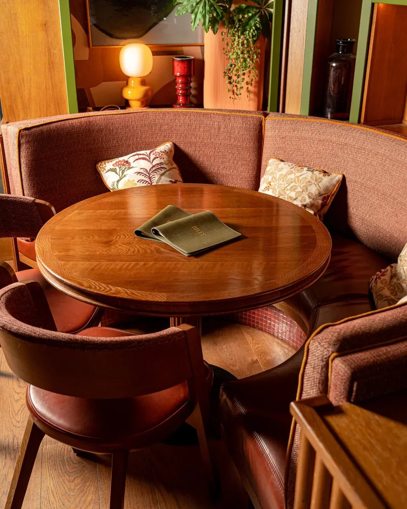 A round table and pink banquettes at Billy